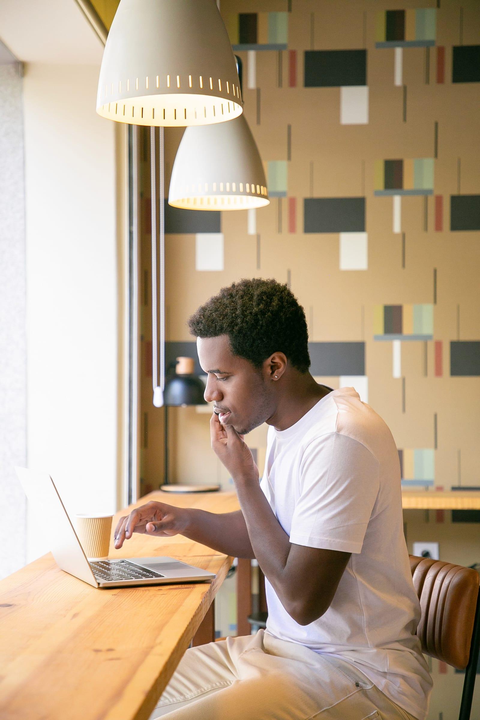 Young man reviewing his visa application on a laptop