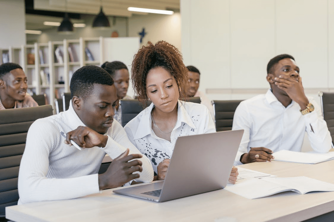 Students working on applications together on a laptop